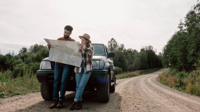 Reading map in front of overlander SUV